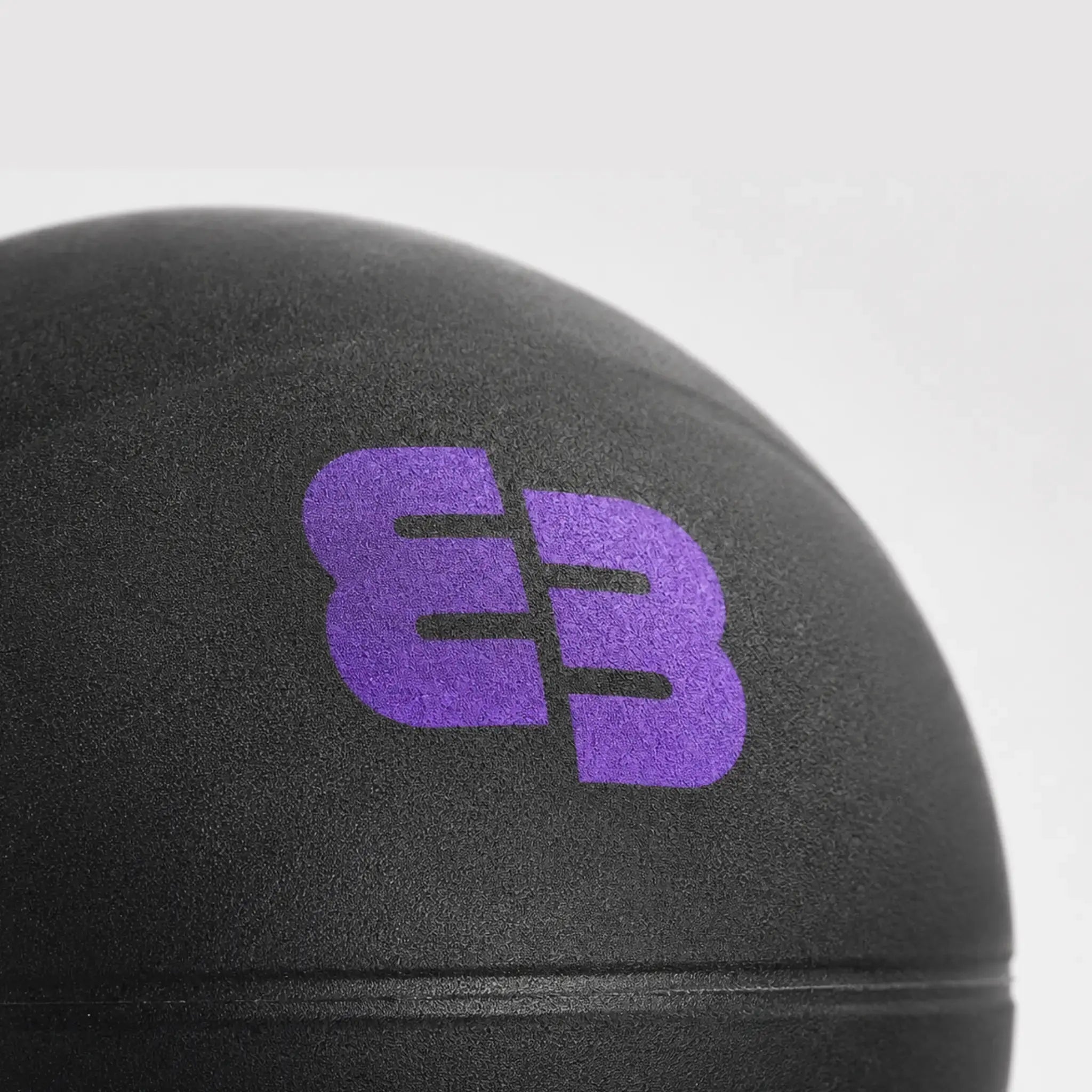 Gros plan sur la texture micro-grainée du Silent Beatball® noir avec logo BB violet.